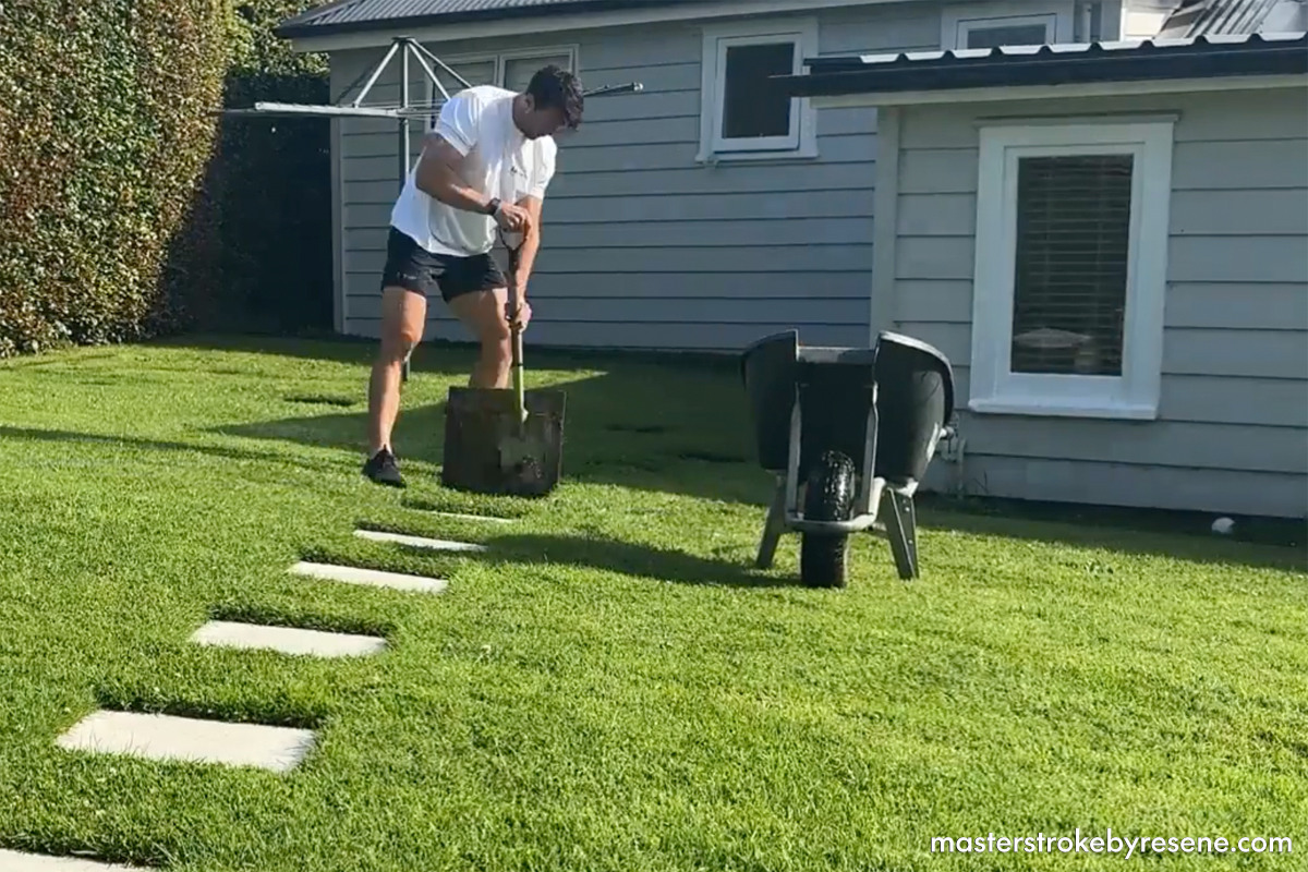 man uses spade to remove garden pavers from grass