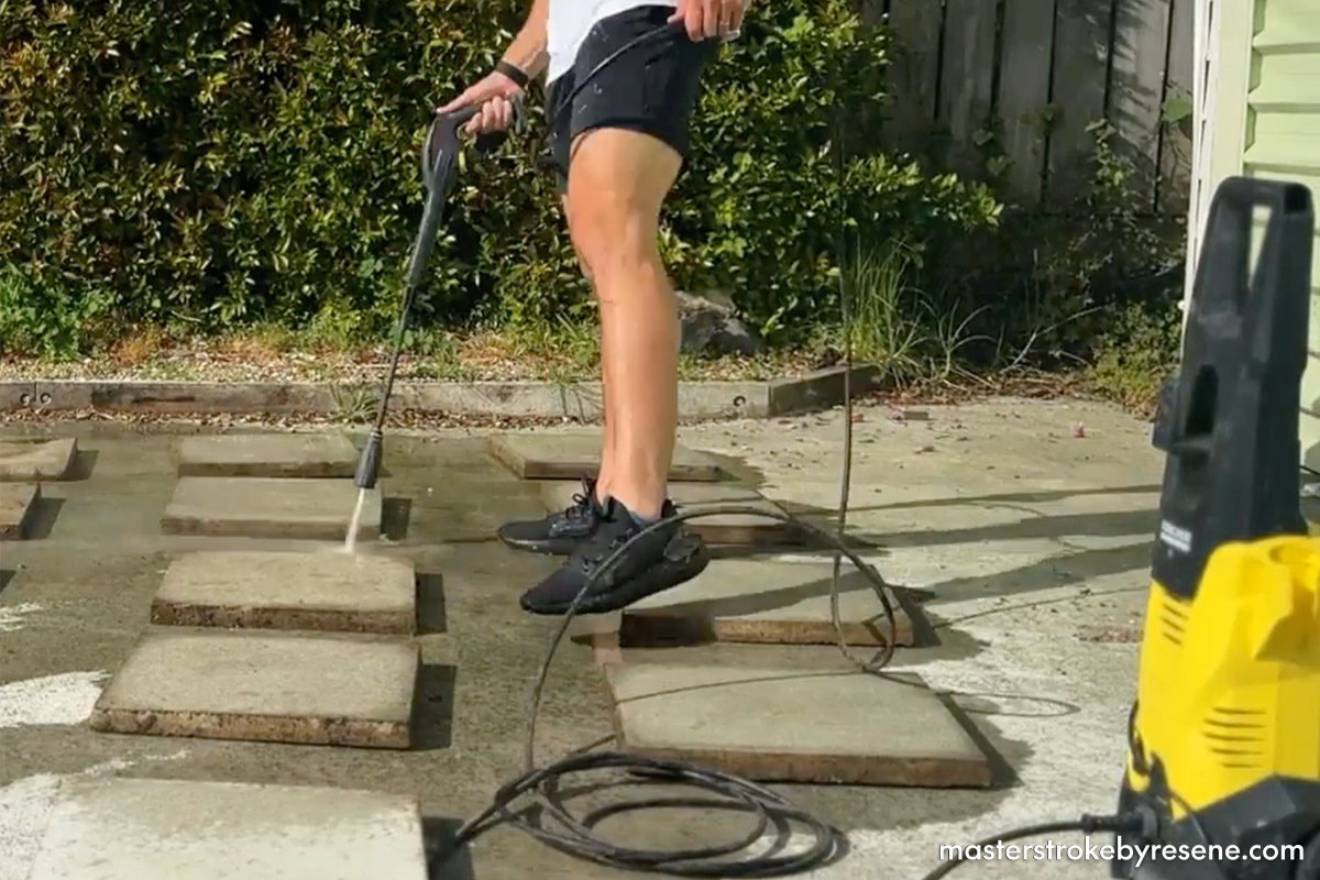 man used water blaster to clean paving stones